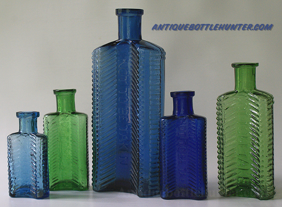 A light steel blue (2 - 7/8 in.), light green (3 - 1/2 in.), steel blue (6 - 3/8 in.), dark blue (3 - 1/2 in.), and finally a yellow green (4 - 1/2 in.) set of KU-21s --- AntiqueBottleHunter.com 